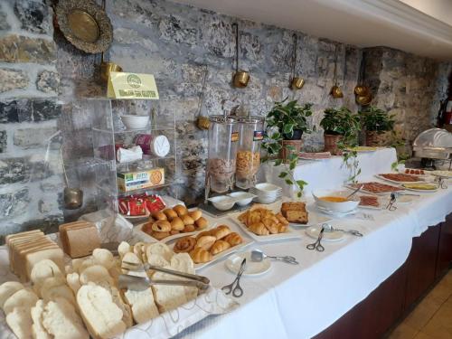 um buffet de pão e produtos de pastelaria numa mesa em Hotel Palacio de la Magdalena em Soto del Barco