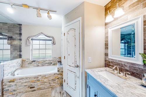 a bathroom with two sinks and a tub and a window at Sunkissed in Kissimmee in Kissimmee