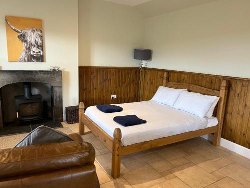 a bedroom with a bed and a fireplace at Traditional bothy accommodation in Blairgowrie