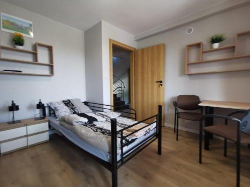 1 dormitorio con 1 cama, 1 mesa y 1 silla en Tanie Noclegi, kwatery, pokoje do wynajęcia , TARGI KIELCE en Kielce