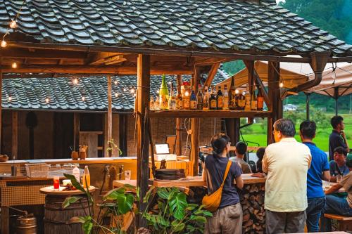 a group of people sitting at a bar at a restaurant at 古民家オーベルジュmocca in Kokuryō