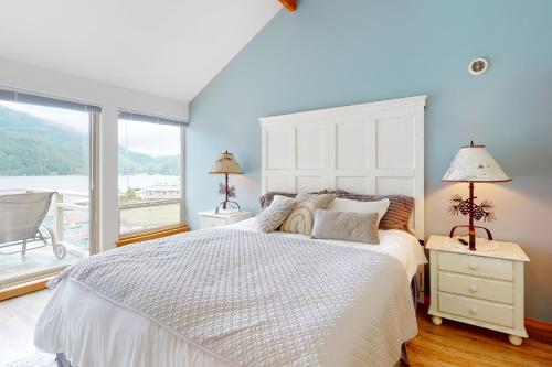 a bedroom with a large white bed and a large window at Lake Sutherland Retreat in Port Angeles