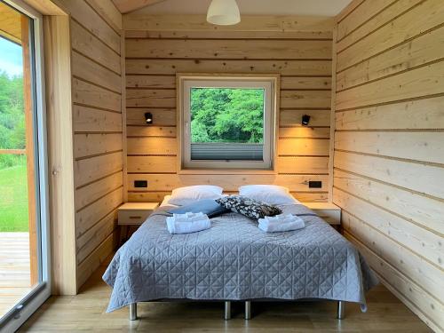 a bedroom with a bed in a room with a window at 3pokoje - Domek lub Pokój pod lasem na odludziu, jacuzzi, sauna, kominek, Roztocze in Susiec