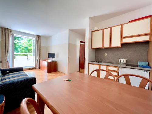 a living room with a table and a kitchen at Villa Valdepian Apartments in Savudrija