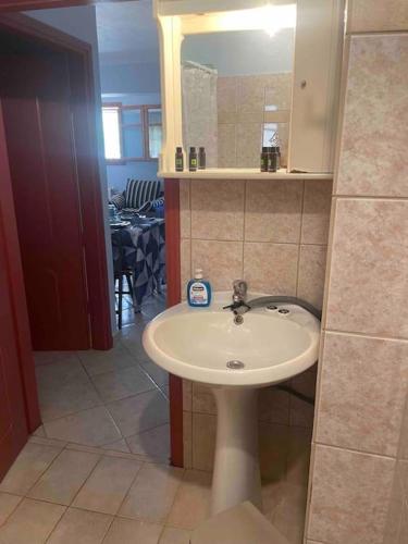 a bathroom with a sink and a mirror at Alice Apartment in Agia Effimia