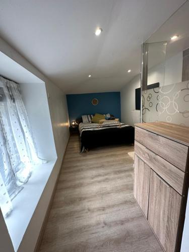 ein Schlafzimmer mit einem Bett in der Ecke eines Zimmers in der Unterkunft Maison au calme in Le Fief-Sauvin