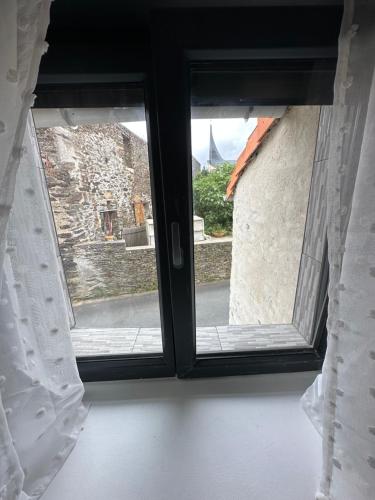 una ventana abierta con vistas a un edificio en Maison au calme en Le Fief-Sauvin