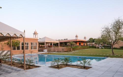 曼达瓦Aangan Resort的带游泳池的房子图片