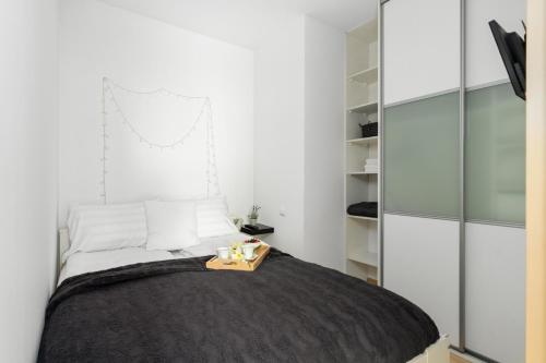 um quarto com uma cama com uma bandeja de madeira em Cozy Apartment Karpia 17 with Terrace & PARKING in Poznań by Renters em Poznań