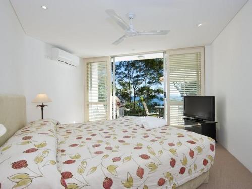 a bedroom with a bed and a large window at Kareka Apartment 2, Little Cove in Noosa Heads