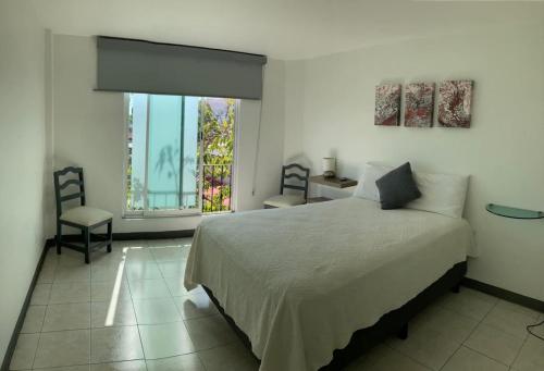 a bedroom with a large bed and a window at Nomada in Oaxaca City