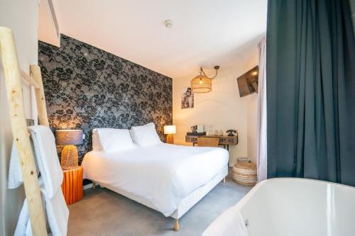 um quarto com uma grande cama branca e cortinas verdes em La Finca Hôtel & Spa em Paris