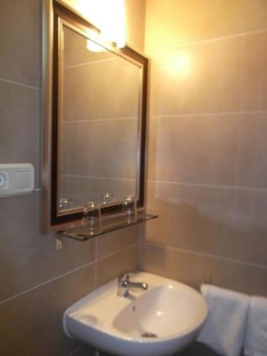 a bathroom with a sink and a mirror and towels at Residencia Sant Jordi Llança in Llança