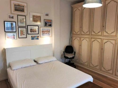 a bedroom with a white bed and a large cabinet at Martini Elegant Apartment in Florence