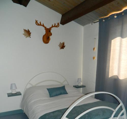 ein Schlafzimmer mit einem Bett mit einem Hirschkopf an der Wand in der Unterkunft Le Clos Des Dryades d in Vers