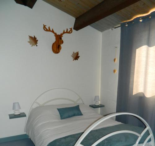 a bedroom with a bed with a deer head on the wall at Le Clos Des Dryades d in Vers