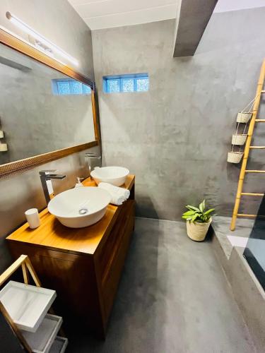 a bathroom with two sinks and a mirror at La Caze Grande Anse in Petite Île
