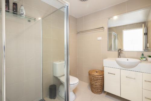 a bathroom with a toilet and a sink and a shower at 2 Bedroom! Great Location & Walk to Train in Brisbane