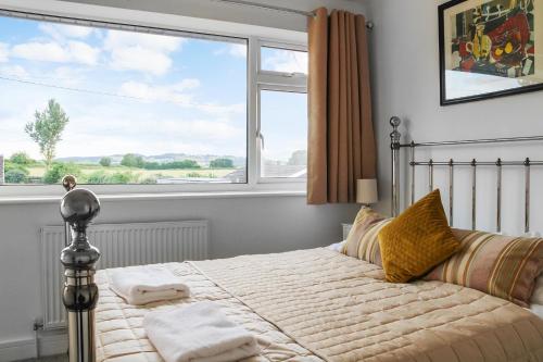 a bedroom with a bed with a large window at Stunning 4 bedroom home near cotswolds and Stratford upon avon in Tredington