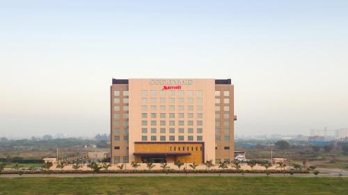 a building with a sign on top of it at Courtyard by Marriott Surat in Surat
