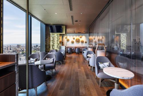 a waiting room at a restaurant with chairs and tables at Centara Grand Hotel Osaka in Osaka