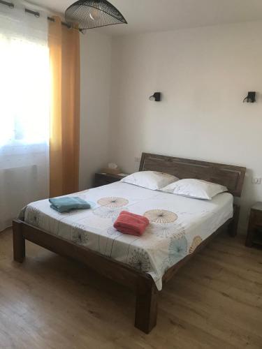 um quarto com uma cama com três almofadas em Aux coquelicots sauvages em Pont-Saint-Martin