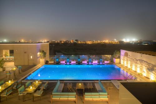 a swimming pool on top of a building at night at Courtyard by Marriott Surat in Surat