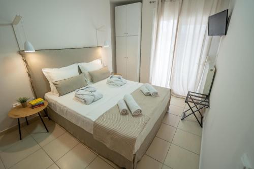 a bedroom with a bed with towels on it at Elia Family Apartment in Neos Marmaras