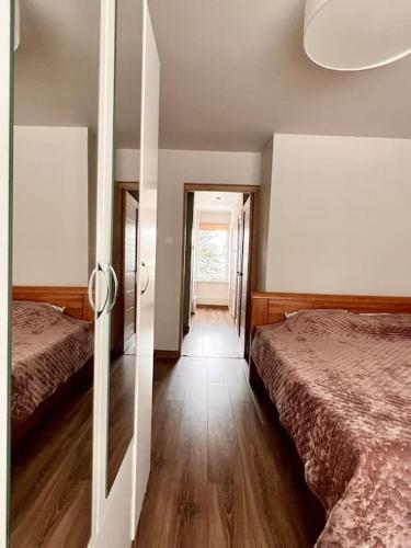 a bedroom with two beds and a hallway with a doorway at Refurnished Apartment in Rucava in Rucava