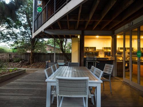 a wooden table and chairs on a wooden deck at YHA Apollo Bay Eco in Apollo Bay