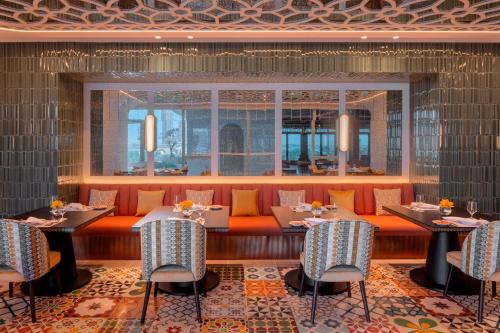 a dining room with tables and chairs and a window at Avani Plus Palm View Dubai Hotel & Suites in Dubai