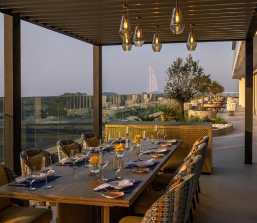 a long table in a restaurant with a view at Avani Plus Palm View Dubai Hotel & Suites in Dubai