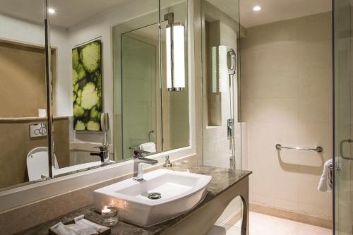 a bathroom with a sink and a mirror at Singhania Sarovar Portico in Raipur