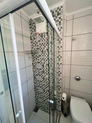 a bathroom with a glass shower with a toilet at Apartamento Moderno in Rio de Janeiro