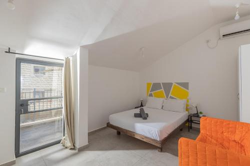 A bed or beds in a room at Accommodation Apartments In The Heart Of The Nachlaot Neighborhood