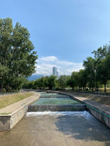a water fountain in a park with a city in the background at Стильная студия Shadow Атакент in Almaty