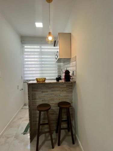 - une cuisine avec deux tabourets et un comptoir dans une pièce dans l'établissement Apartamento Moderno, à Rio de Janeiro