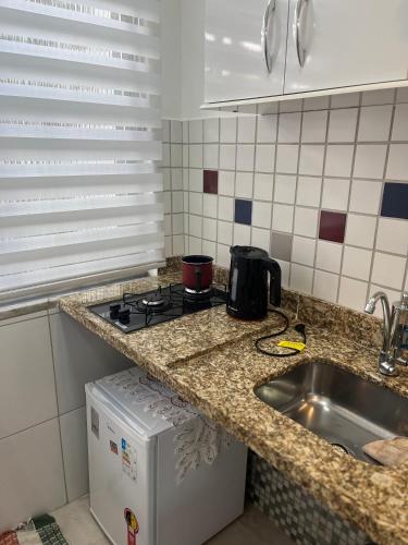 um balcão de cozinha com um lavatório e um fogão em Apartamento Moderno no Rio de Janeiro