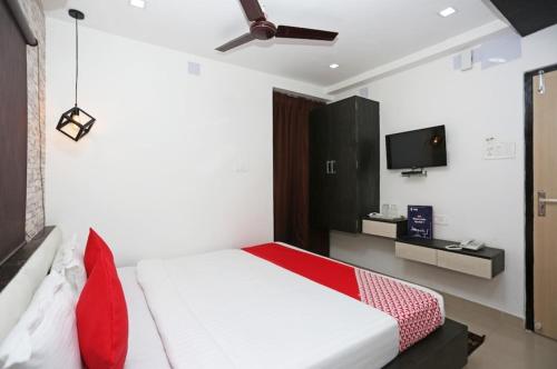 a bedroom with a white bed and a tv at SSJ Premium in Bhubaneshwar