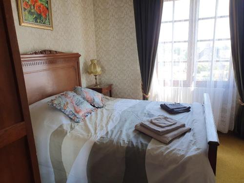 a bed with two towels on it in a bedroom at Maison dans le bourg in Les Pieux