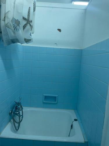 - une salle de bains pourvue de carrelage bleu et d'une baignoire lumineuse dans l'établissement Chateau du Donjon, à Drumettaz-Clarafond