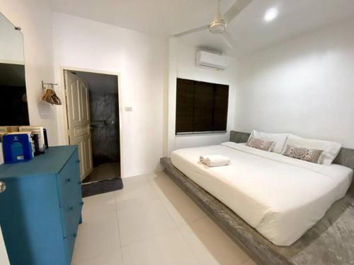 a white bedroom with a large bed and a blue dresser at Orchid Villa in Koh Tao