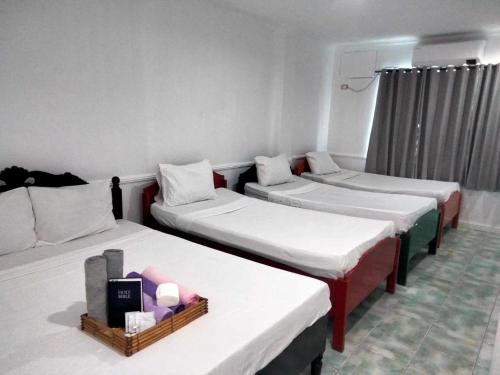 a room with three beds in a room at North Shores Inn in Currimao