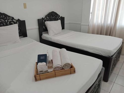 two beds with towels and a tray of towels at North Shores Inn in Currimao