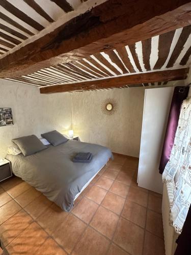 une chambre avec un grand lit dans une pièce dans l'établissement Grand Mas Provençal rénové avec piscine-plage, à Cavaillon