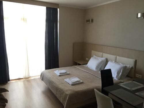 1 dormitorio con 1 cama con 2 toallas en Batumi21 en Batumi