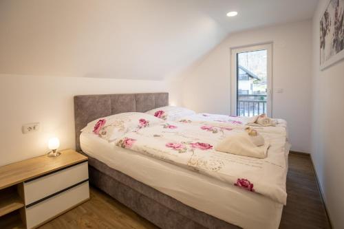 een slaapkamer met een groot bed en een dressoir bij Apartment CRYSTAL AURA 1 in Bohinj