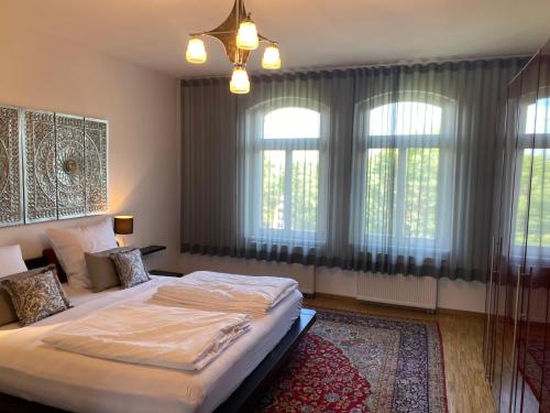 a bedroom with a large bed with windows and a rug at Helsinki Apartment 2 in Erfurt