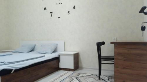 a bedroom with a bed and a desk and a chair at Begzod's room in Samarkand