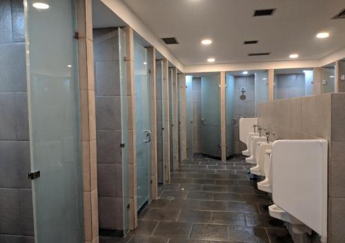 a bathroom with a row of urinals and stalls at Astara Hotel Balikpapan in Balikpapan